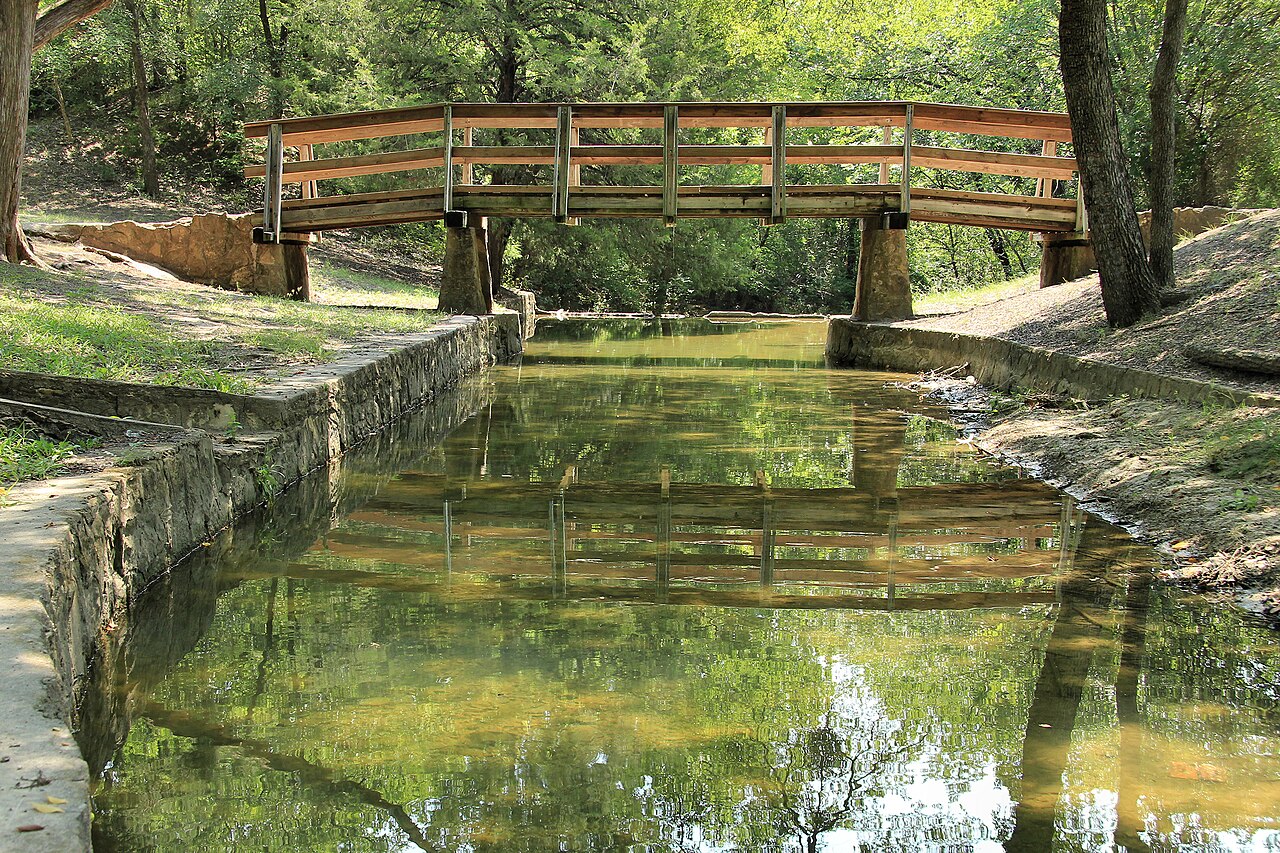A footbridge over a rock-lined channel in Grapevine Springs Preserve, Coppell, Texas