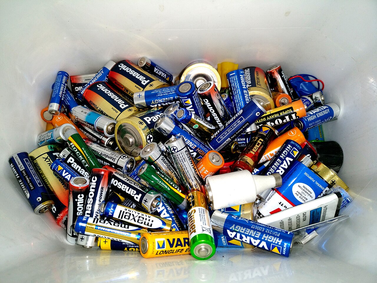 Used household batteries in a battery recycling bin