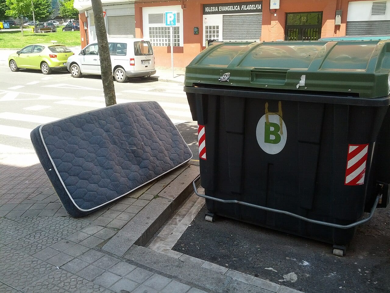 Discarded mattress beside a waste container in Spain Discarded mattress beside a waste container in Spain