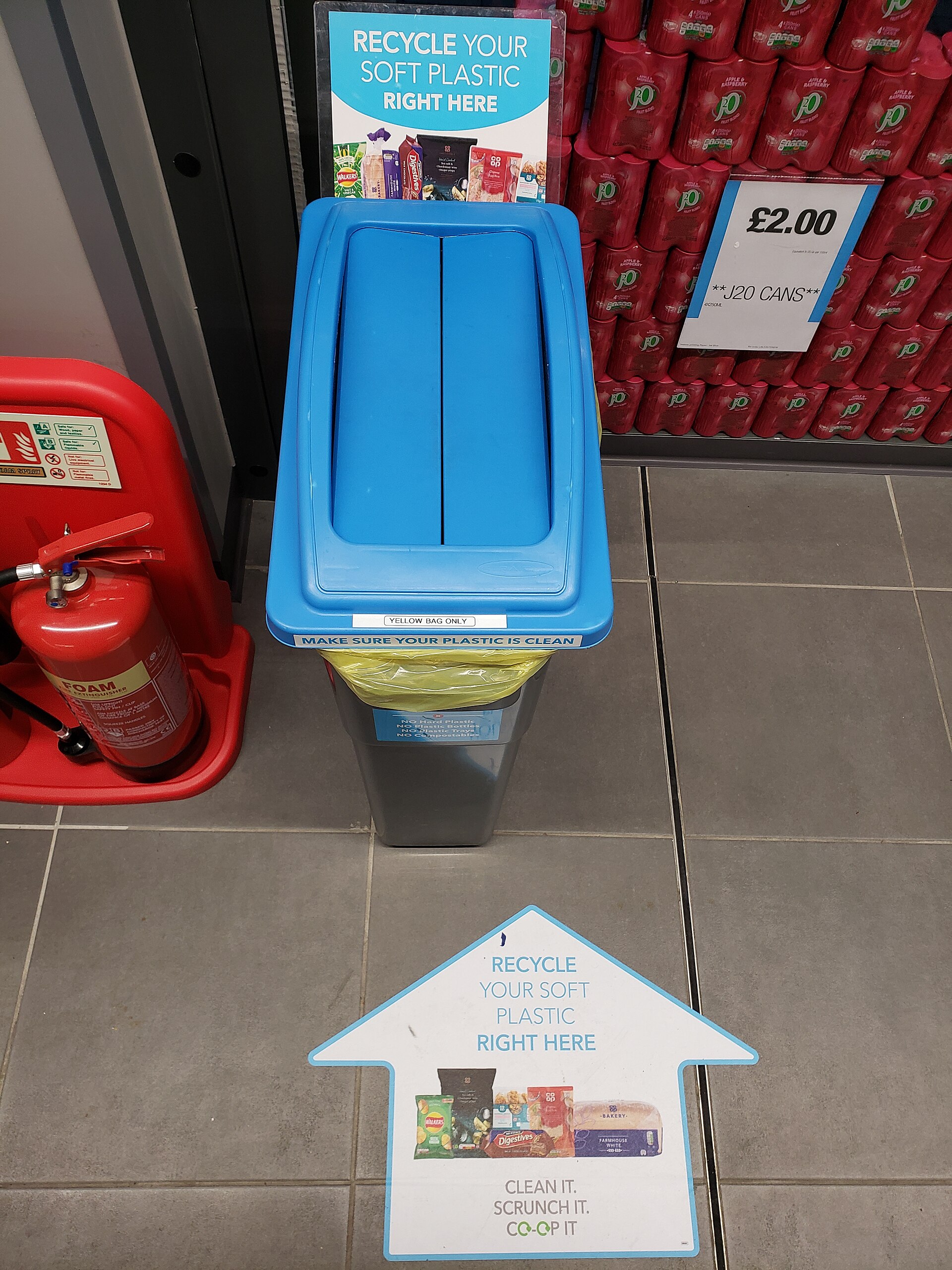 A blue store collection bin for clean soft plastic bags and film, with recycling signs above and on the floor